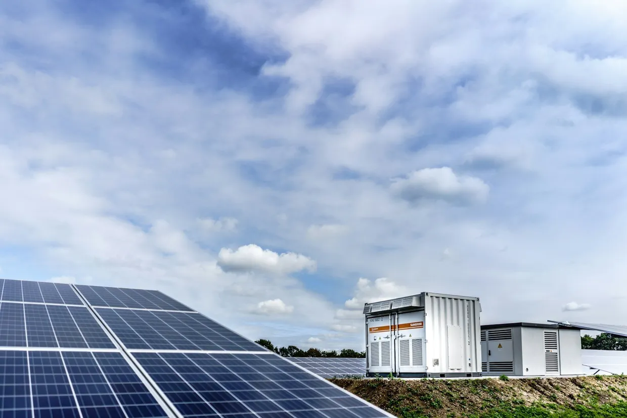Contenedor de almacenamiento en baterías junto a una planta solar